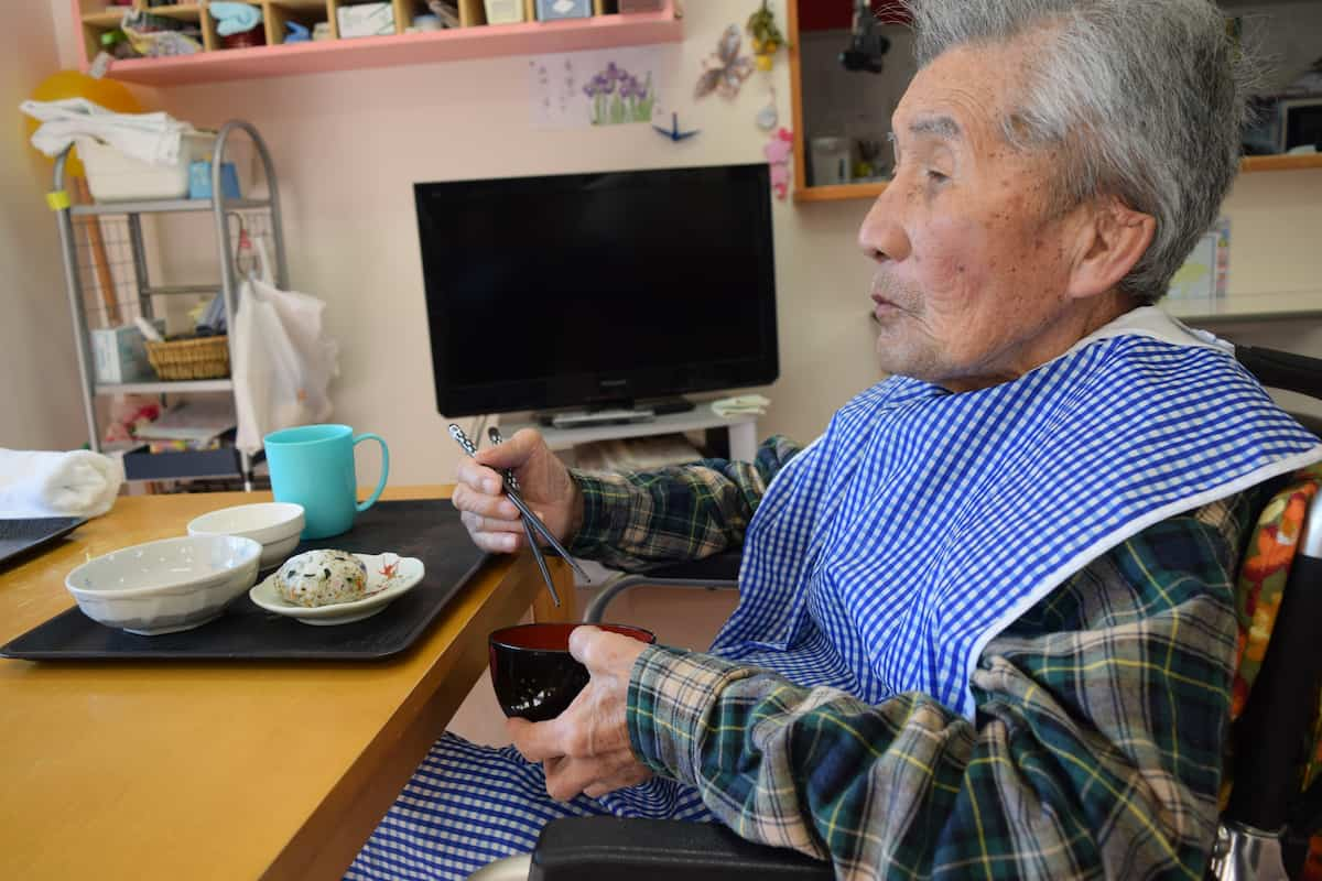 塗りのお椀に入れたトン汁をお箸で食べています。