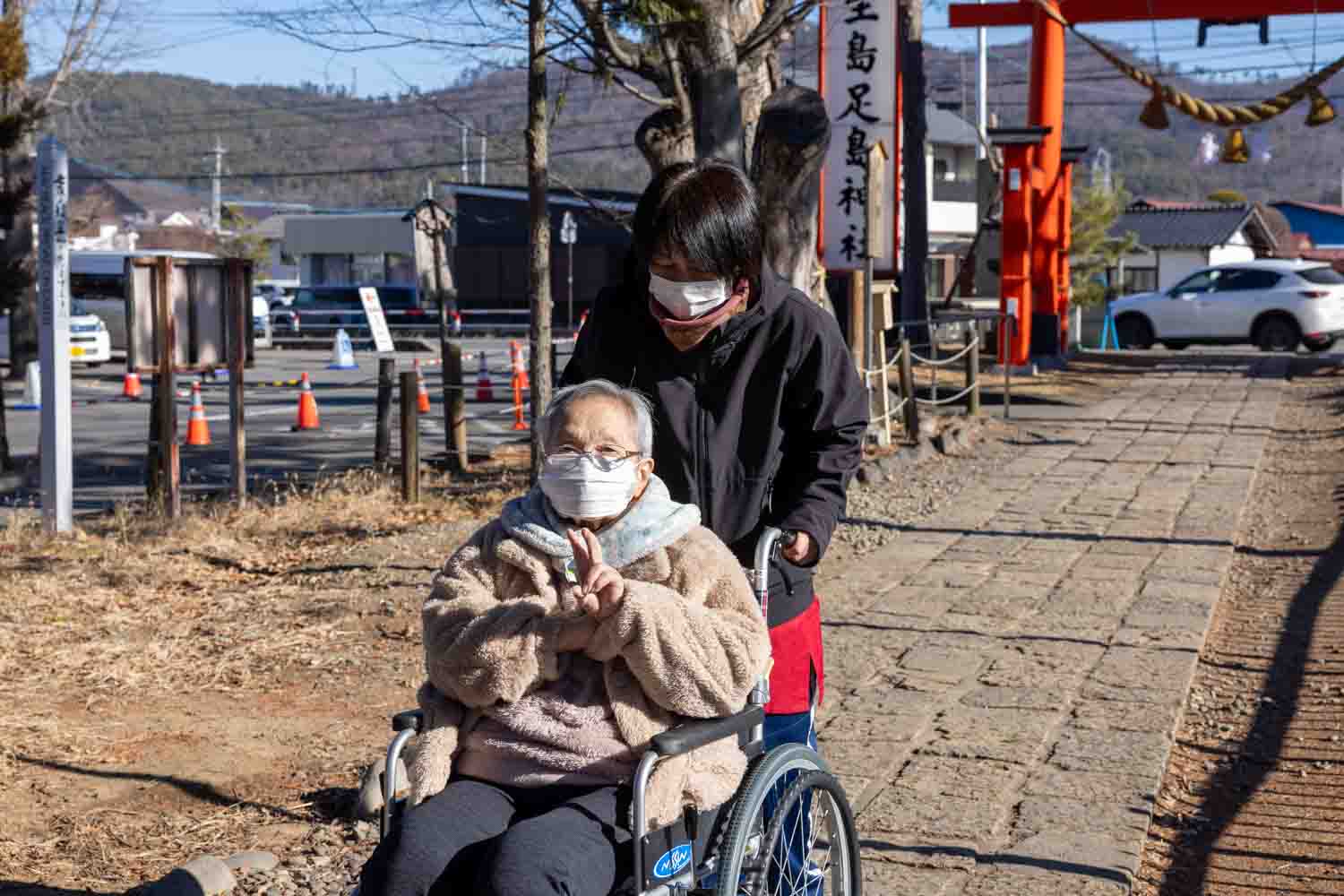 女性の職員も車いすを押して本殿に向かいます。