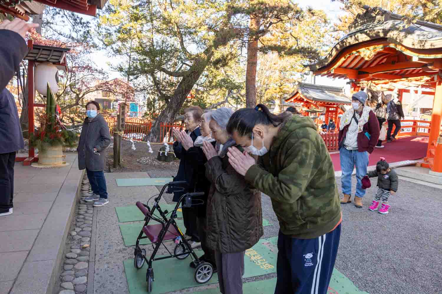 職員と利用者さんが手を合わせてお祈りをしています。