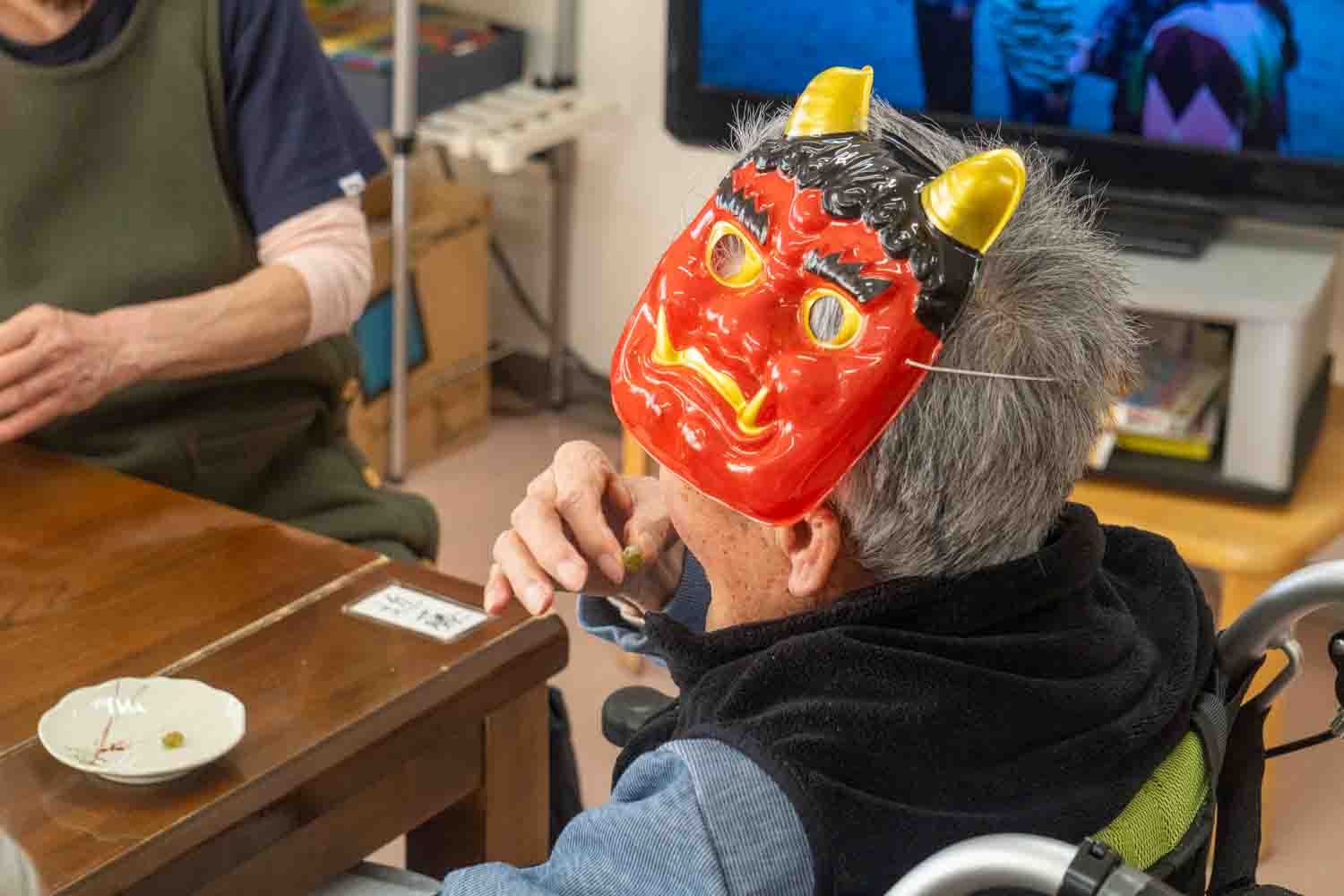 一人の利用者さんが鬼の被り物をしながらおやつを食べていました。