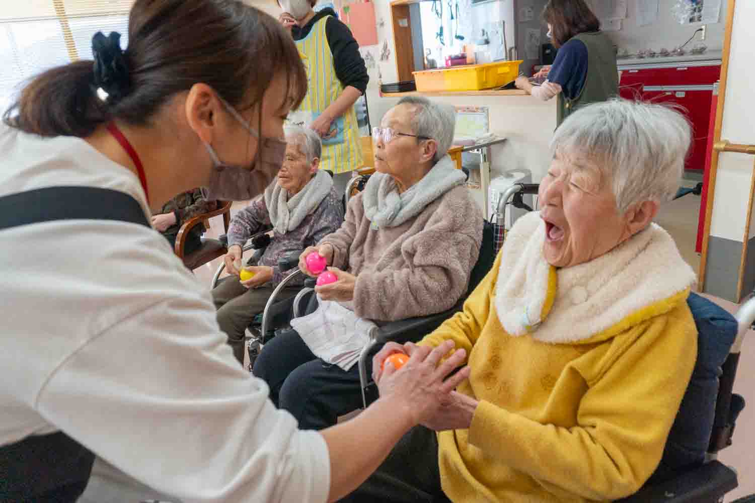 職員が利用者さんそれぞれにボールを手渡ししています。