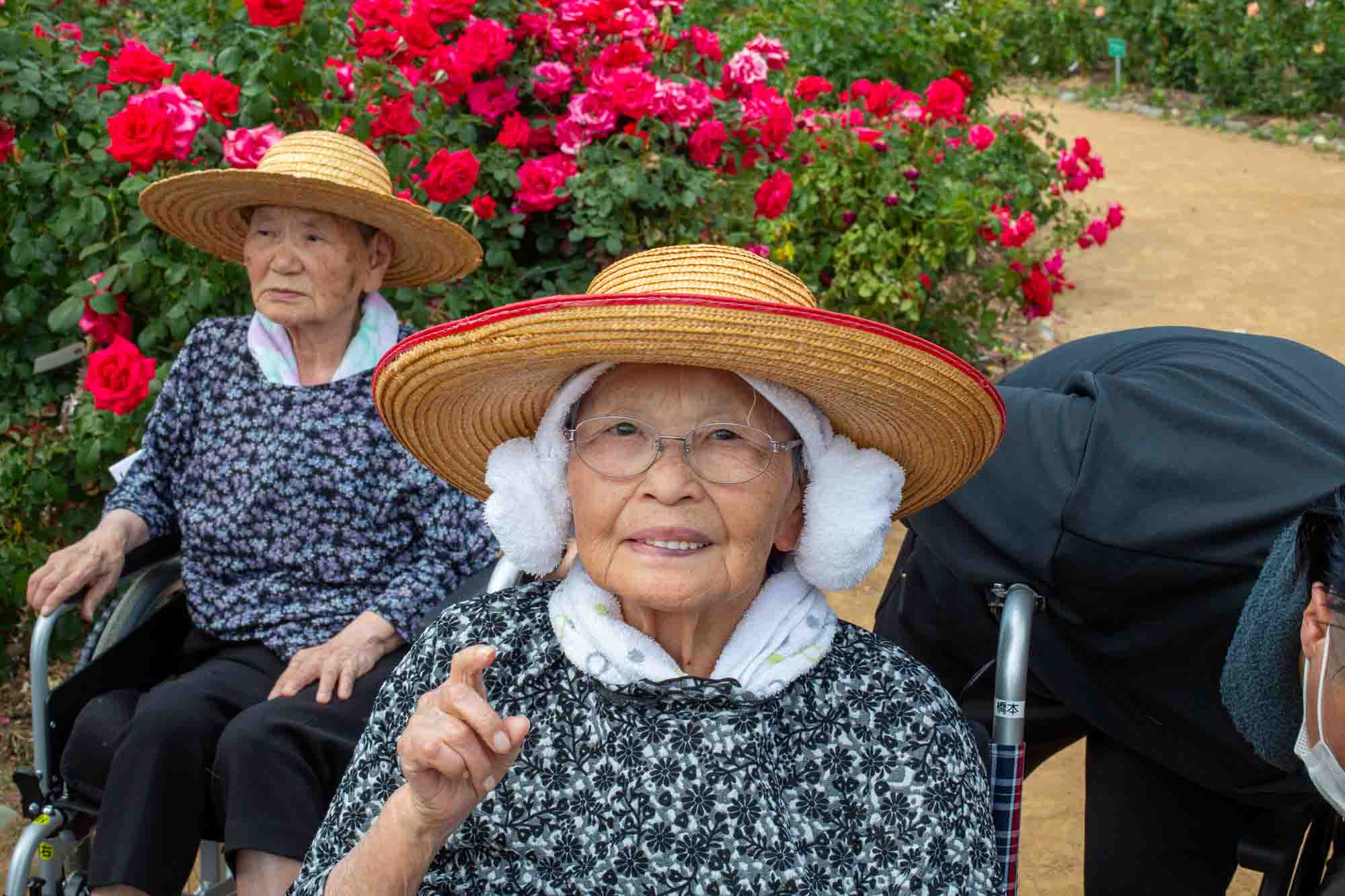 羊タオルを巻き、その上から帽子をかぶっている笑顔の利用者さん