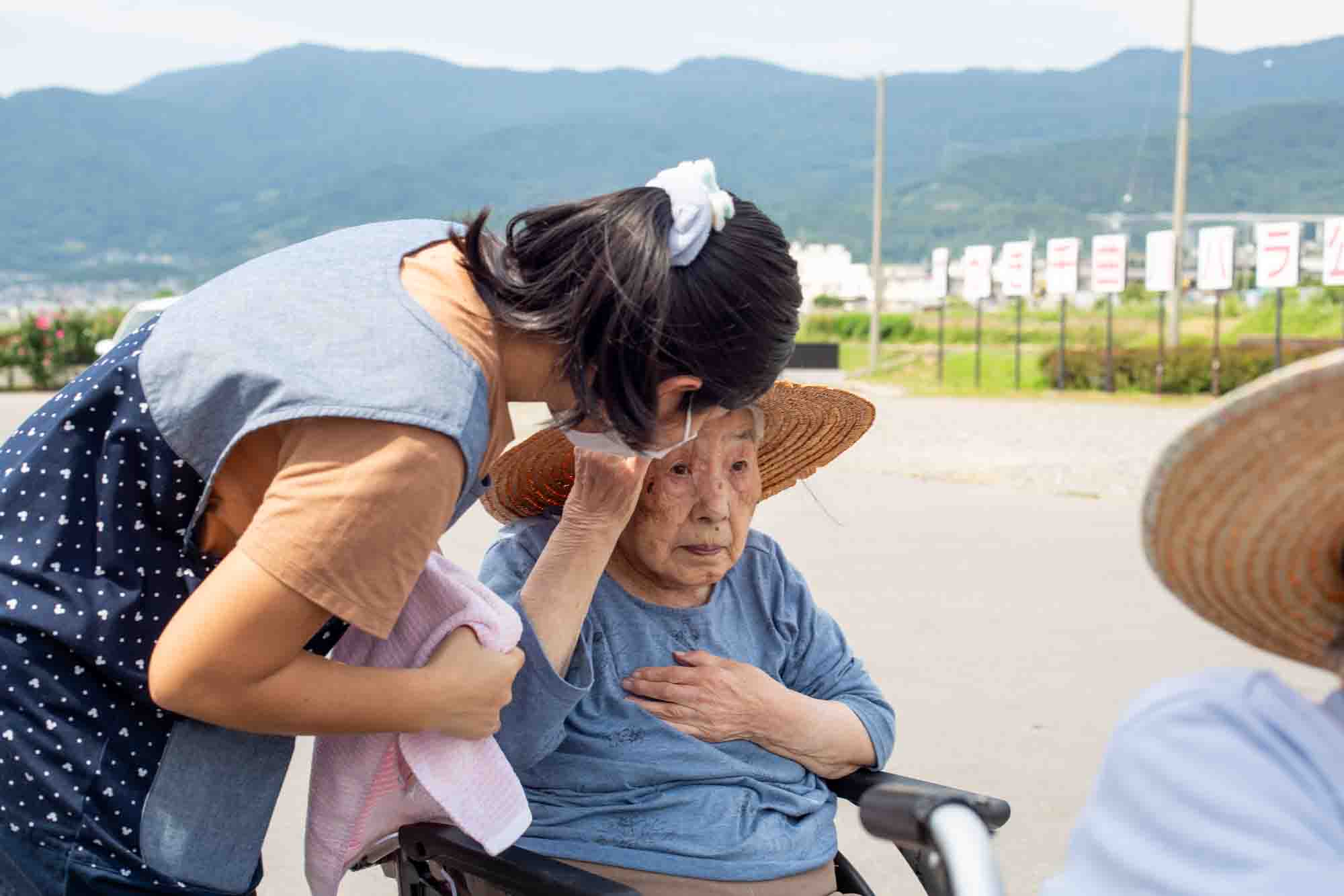 介護職員から帽子をかぶせてもらっている利用者さん