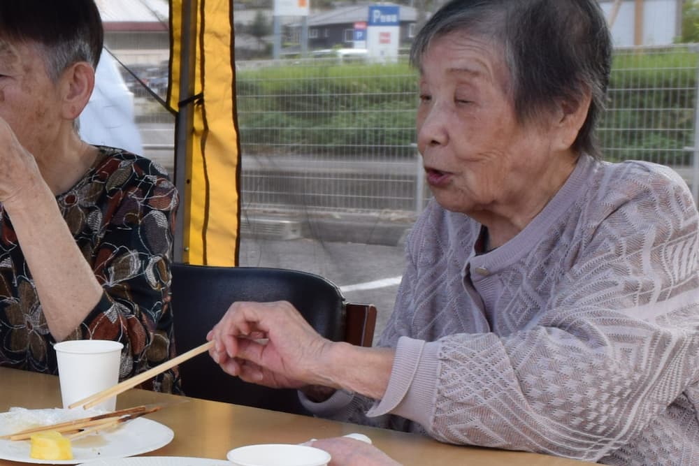 最後のパイナップルを食べようとしている利用者さん