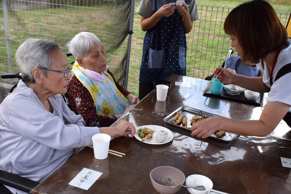 お肉を配るスタッフと、おかわりする利用者さん。