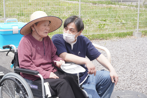 車いすの入居者さんが、スタッフと笑顔で話しています。