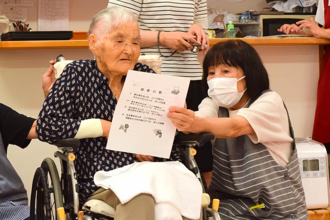 歌詞カードに目を通す入居者さん。