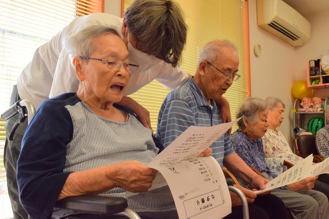 口を大きく開けて歌う入居者さん。