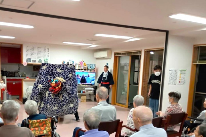 集まった入居者さんの前で、大きな獅子が舞います