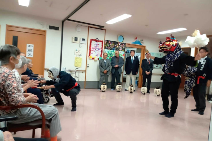 獅子がポーズを決め、ひょっとこが入居者さんに近づきます