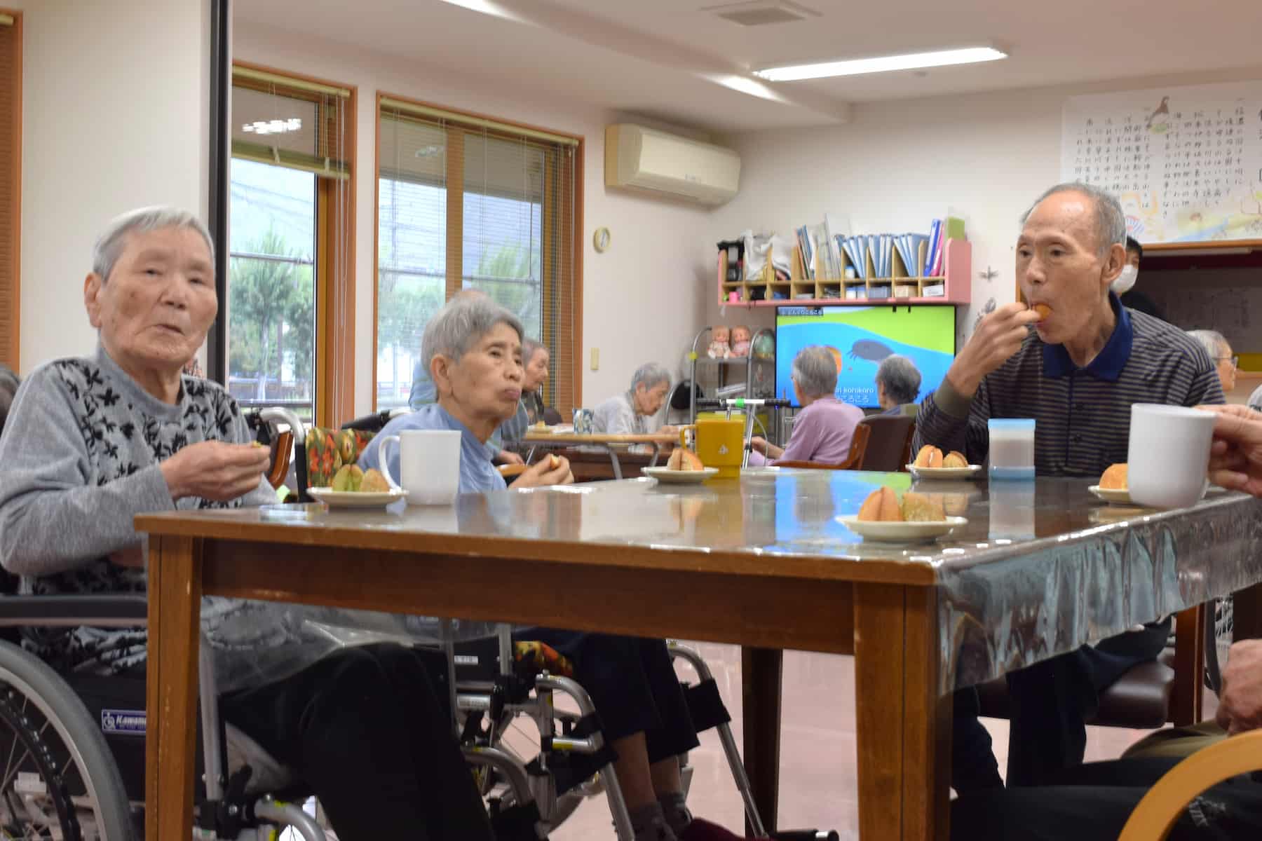 お菓子を口に頬張る入居者さんたち。