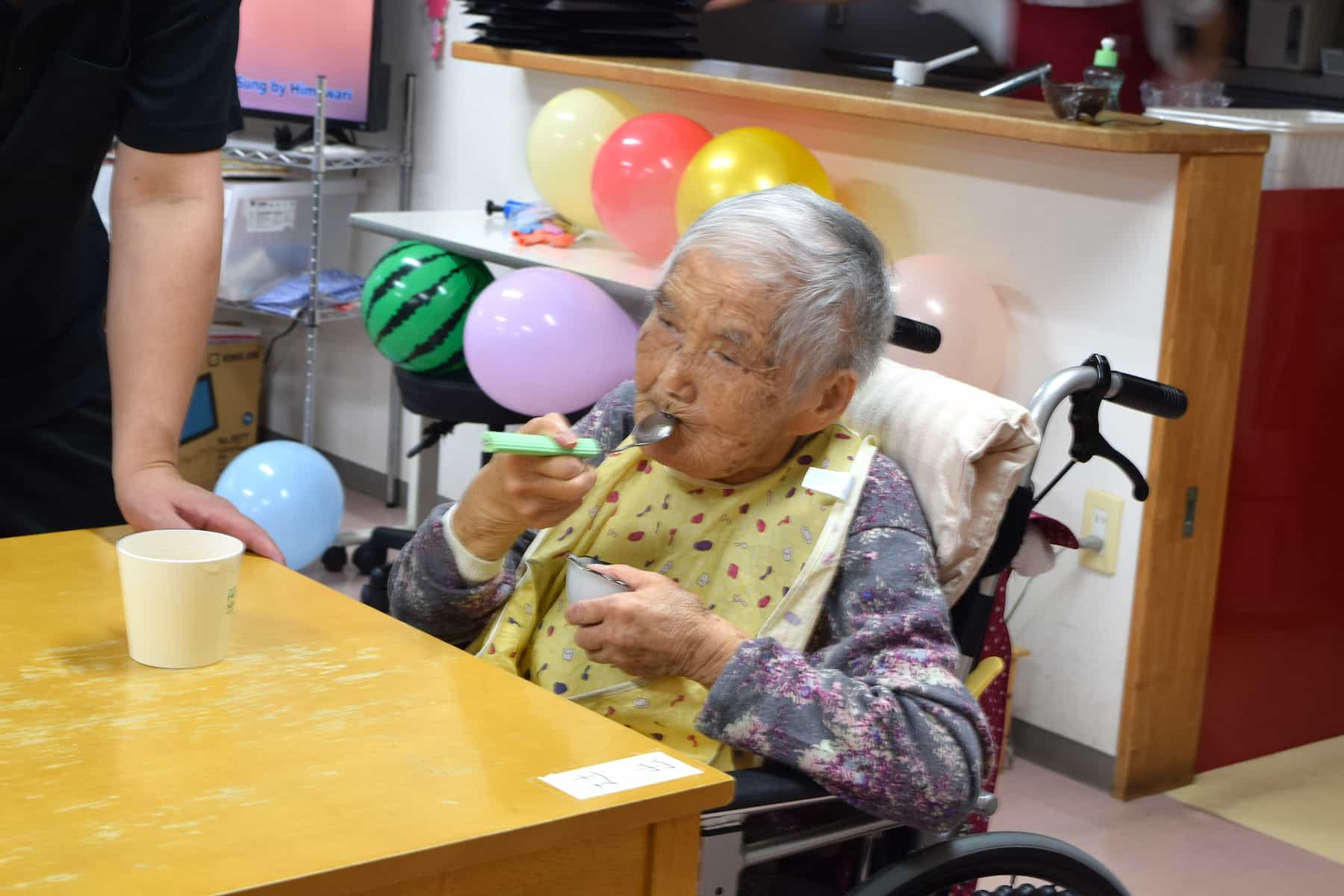 スプーンでおやつを食べる入居者さん。