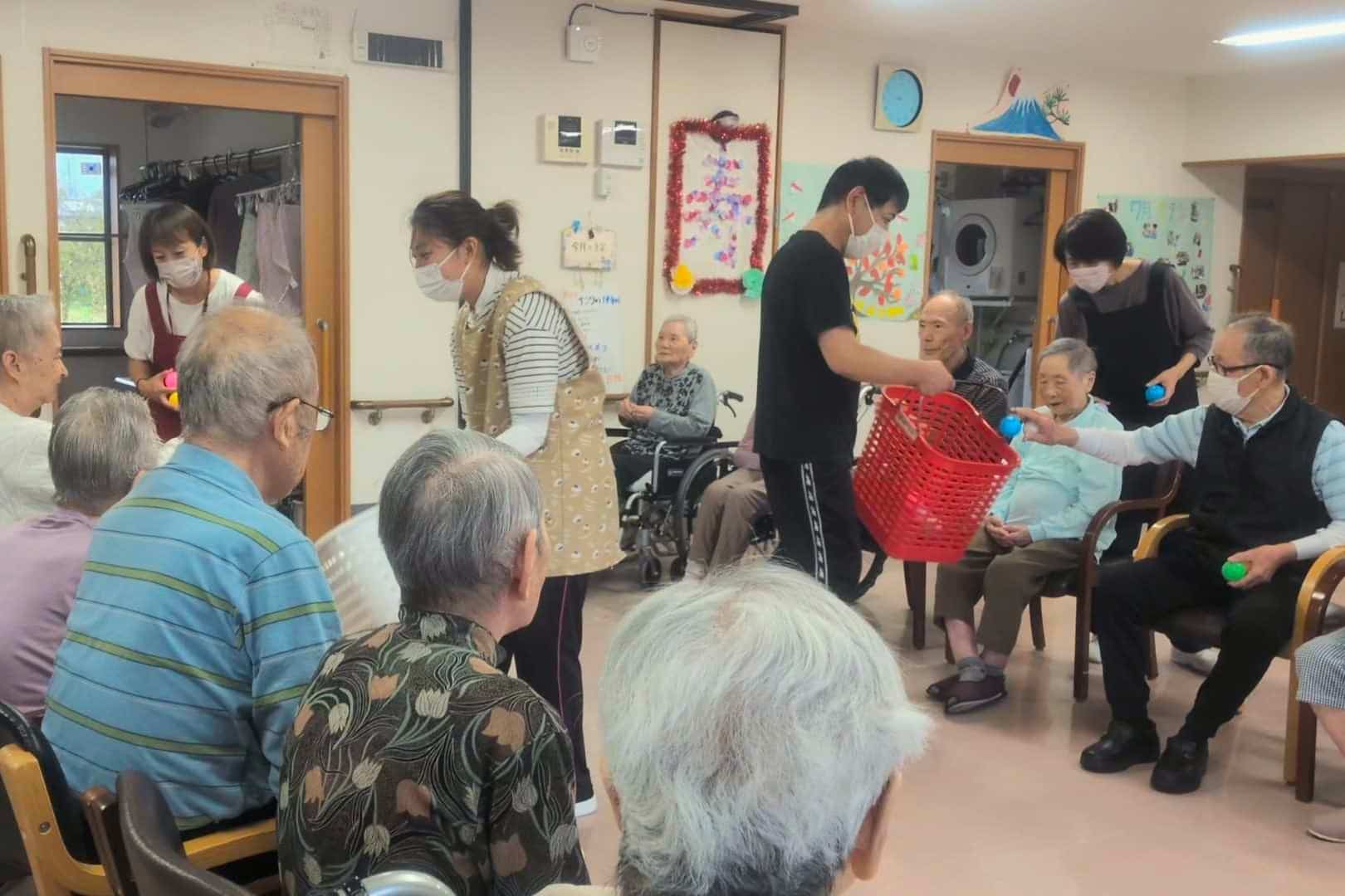 各チーム向き合って座り、スタッフの動かすカゴにボールを入れていきます。