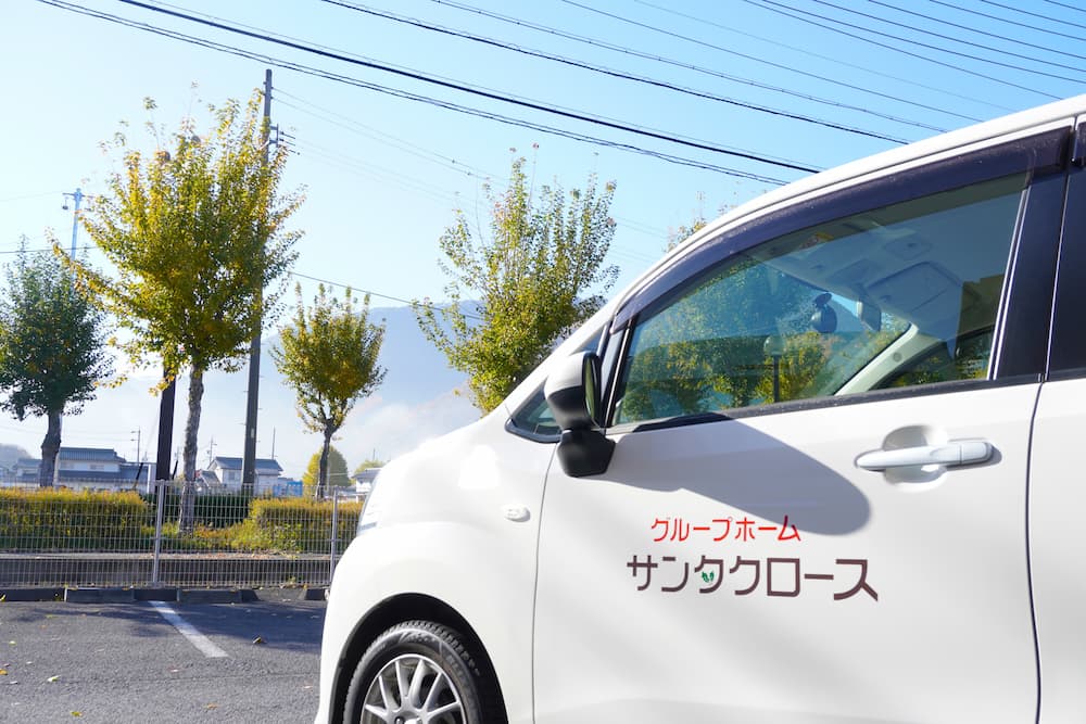 雲一つない空の下、サンタクロースの車が停まっています