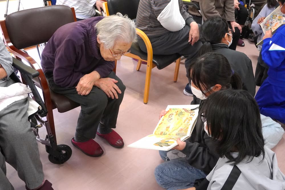 こちらの入居者さんは、身を乗り出して絵本に興味津々。