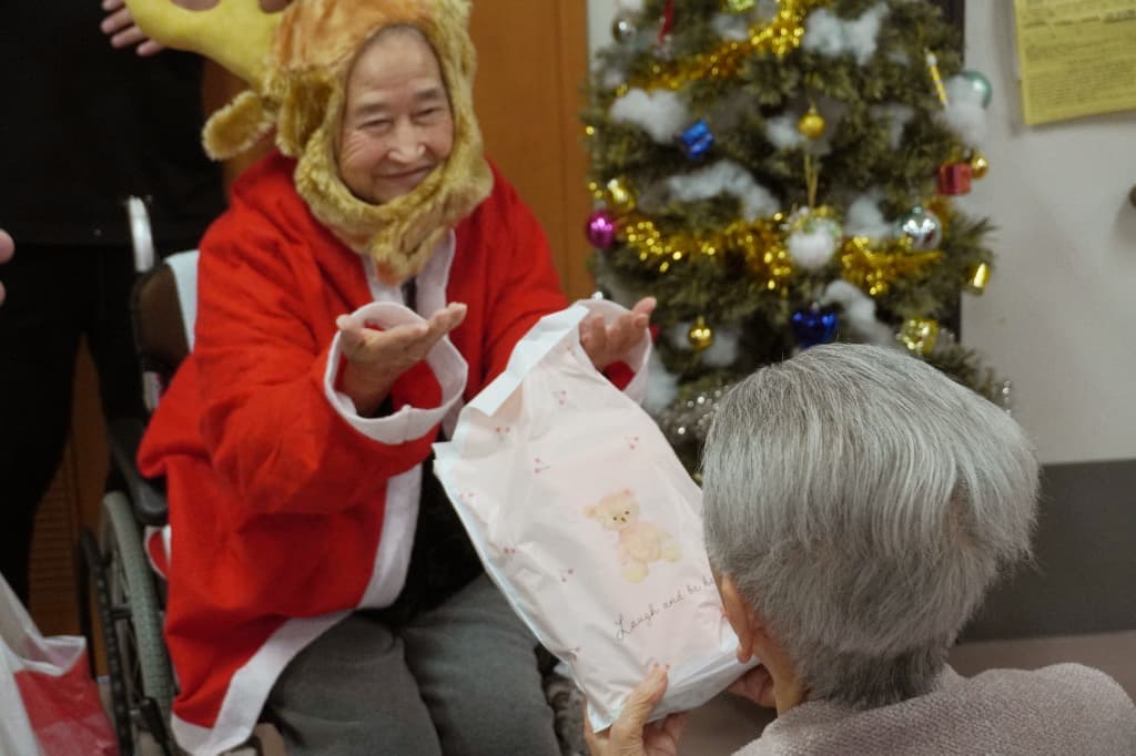 にこにこ笑顔でプレゼントを手渡すトナカイさん