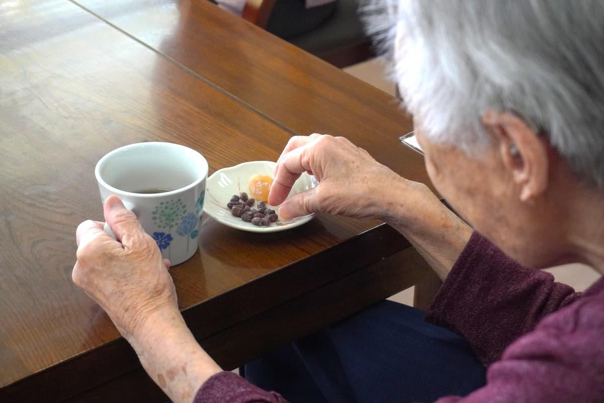 甘納豆を親指と人差し指でつまみます。