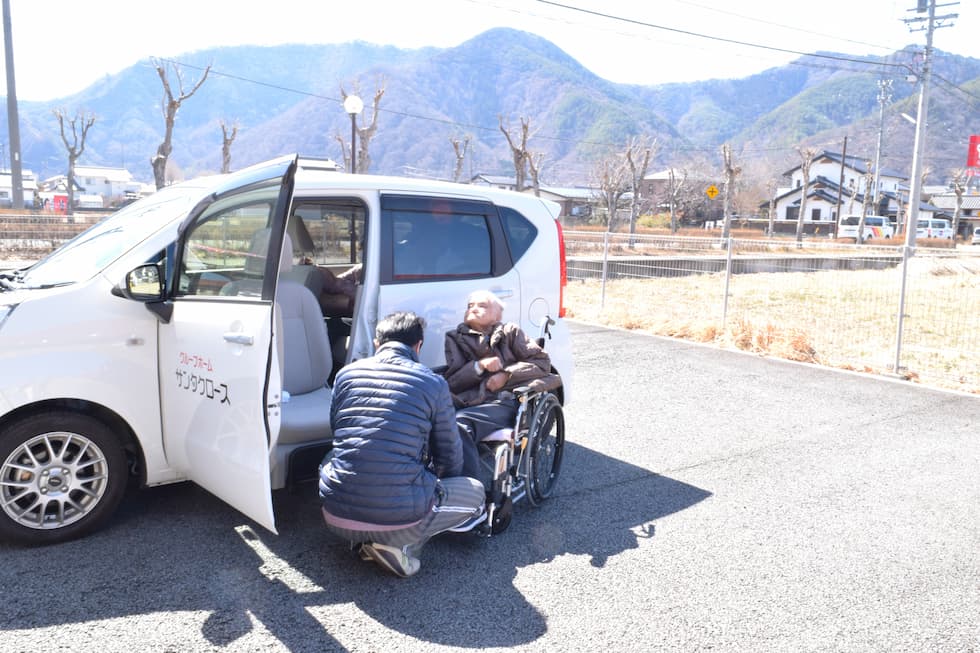 車いすから車に乗り込むために、スタッフがセッティングします。