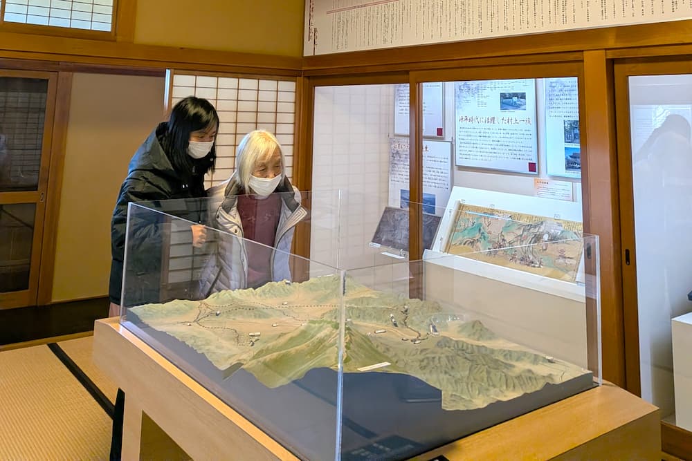 入居者さんがスタッフと一緒に、地形の展示を眺めています。